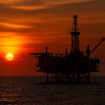 Plataforma petrolera en alta mar al atardecer en Campeche, símbolo de la Enfermedad Holandesa y la dependencia económica del petróleo en México. Imagen para ensayo de Pepe Berzunza sobre desarrollo económico y diversificación productiva.