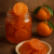 Dulce de mandarina tradicional de Campeche preparado artesanalmente por Pepe Berzunza. Fotografía gastronómica que muestra un frasco de vidrio con rodajas de mandarina confitada en almíbar, sobre una mesa rústica, acompañada de mandarinas frescas con hojas verdes. Imagen del blog De la Fruta al Confite de José Domingo “Pepe” Berzunza Espínola, dedicada a rescatar la gastronomía campechana y promover el emprendimiento local.