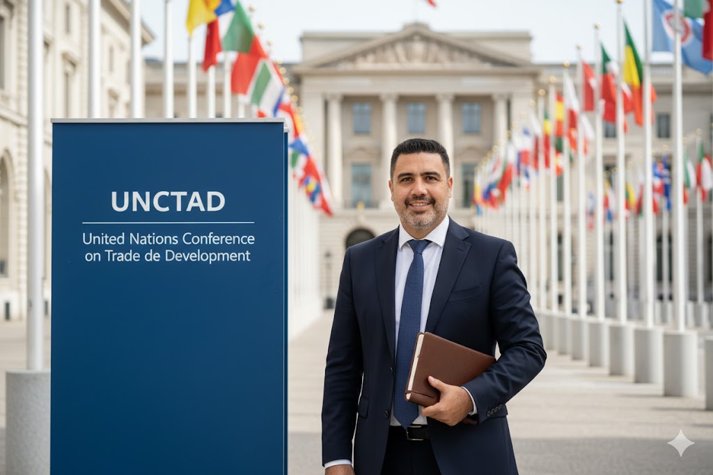 “Pepe Berzunza durante su visita a la sede de la UNCTAD en Ginebra, Suiza, frente a las banderas de Naciones Unidas, en una misión de cooperación internacional sobre políticas de emprendimiento.”