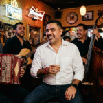 Pepe Berzunza con grupo de corrido norteño en cantina mexicana.